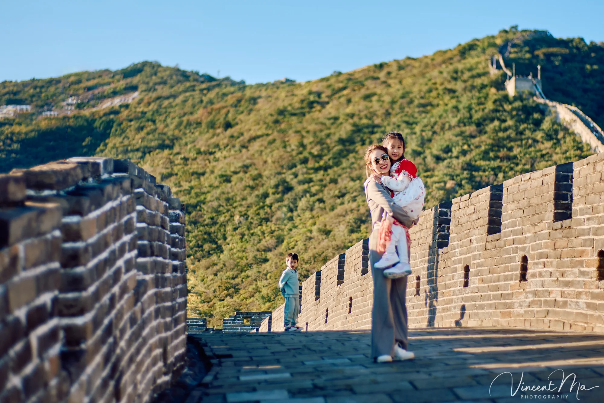 A panoramic view of the Mutianyu Great Wall during a family trip in the afternoon, showing the majestic wall winding through the mountains