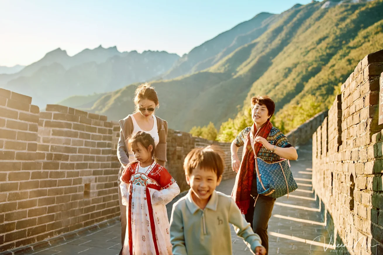 A panoramic view of the Mutianyu Great Wall during a family trip in the afternoon, showing the majestic wall winding through the mountains