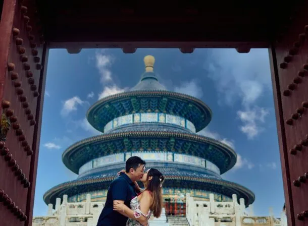 A foreign couple in traditional Chinese - style clothing, the man kneeling on one knee to propose to the woman in front of the majestic Hall of Prayer for Good Harvests in the Temple of Heaven