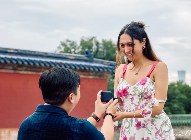 A foreign couple in traditional Chinese - style clothing, the man kneeling on one knee to propose to the woman in front of the majestic Hall of Prayer for Good Harvests in the Temple of Heaven