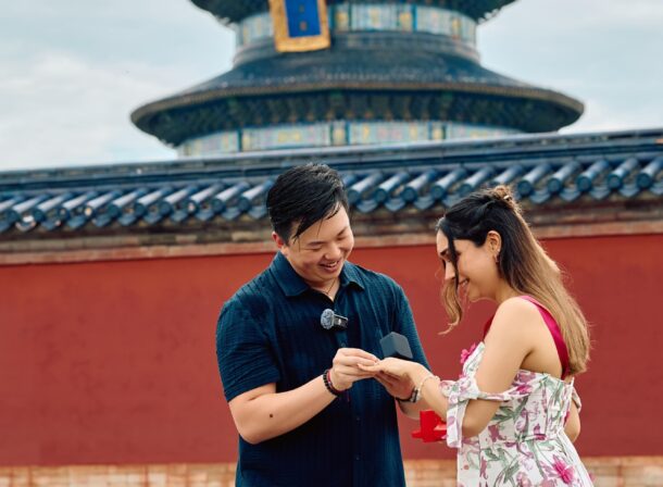 A foreign couple in traditional Chinese - style clothing, the man kneeling on one knee to propose to the woman in front of the majestic Hall of Prayer for Good Harvests in the Temple of Heaven