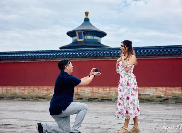 A foreign couple in traditional Chinese - style clothing, the man kneeling on one knee to propose to the woman in front of the majestic Hall of Prayer for Good Harvests in the Temple of Heaven