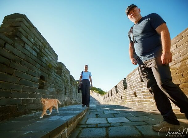 An American couple posing for romantic pictures against the backdrop of Mutianyu Great Wall in Beijing, China. The Great Wall winds through the mountains, and the couple shows their love in the photos