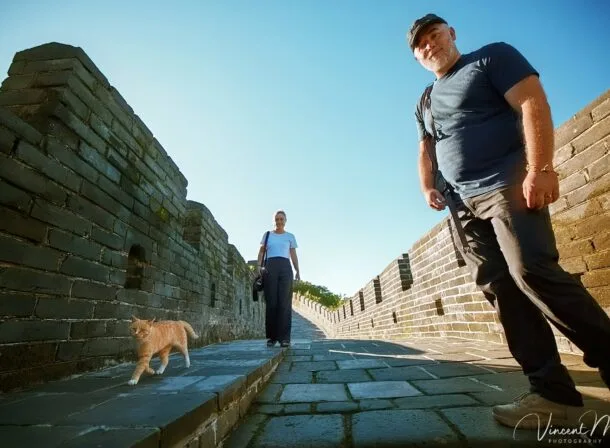 An American couple posing for romantic pictures against the backdrop of Mutianyu Great Wall in Beijing, China. The Great Wall winds through the mountains, and the couple shows their love in the photos