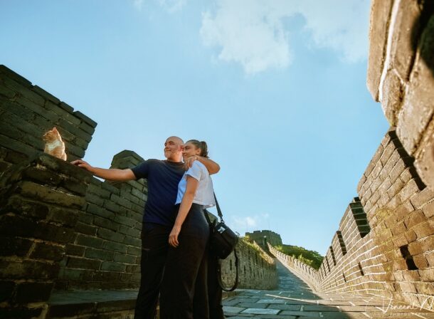An American couple posing for romantic pictures against the backdrop of Mutianyu Great Wall in Beijing, China. The Great Wall winds through the mountains, and the couple shows their love in the photos