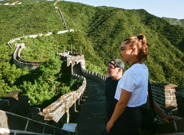 An American couple posing for romantic pictures against the backdrop of Mutianyu Great Wall in Beijing, China. The Great Wall winds through the mountains, and the couple shows their love in the photos