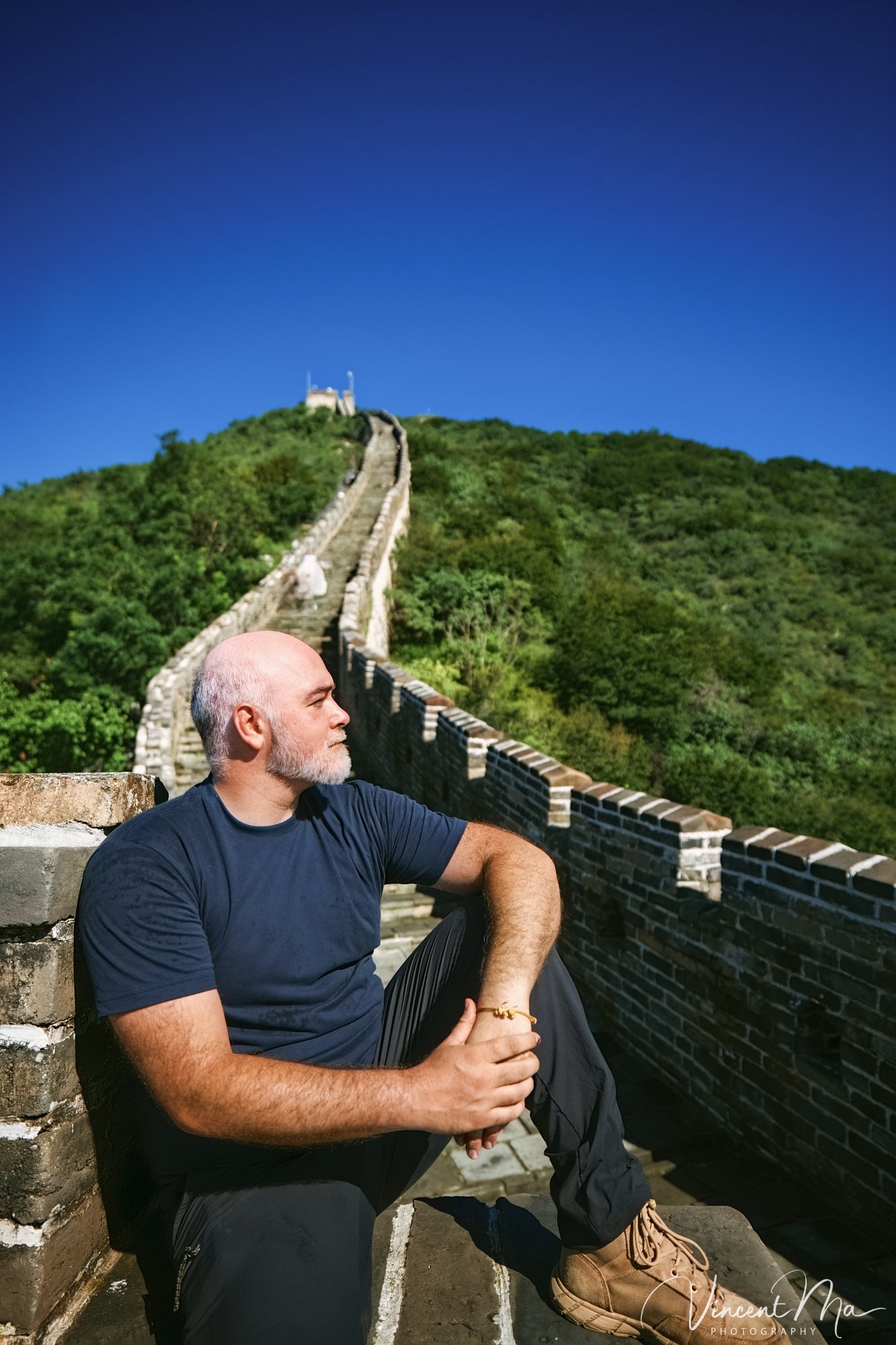 An American couple posing for romantic pictures against the backdrop of Mutianyu Great Wall in Beijing, China. The Great Wall winds through the mountains, and the couple shows their love in the photos
