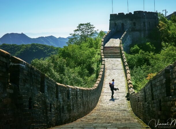 An American couple posing for romantic pictures against the backdrop of Mutianyu Great Wall in Beijing, China. The Great Wall winds through the mountains, and the couple shows their love in the photos