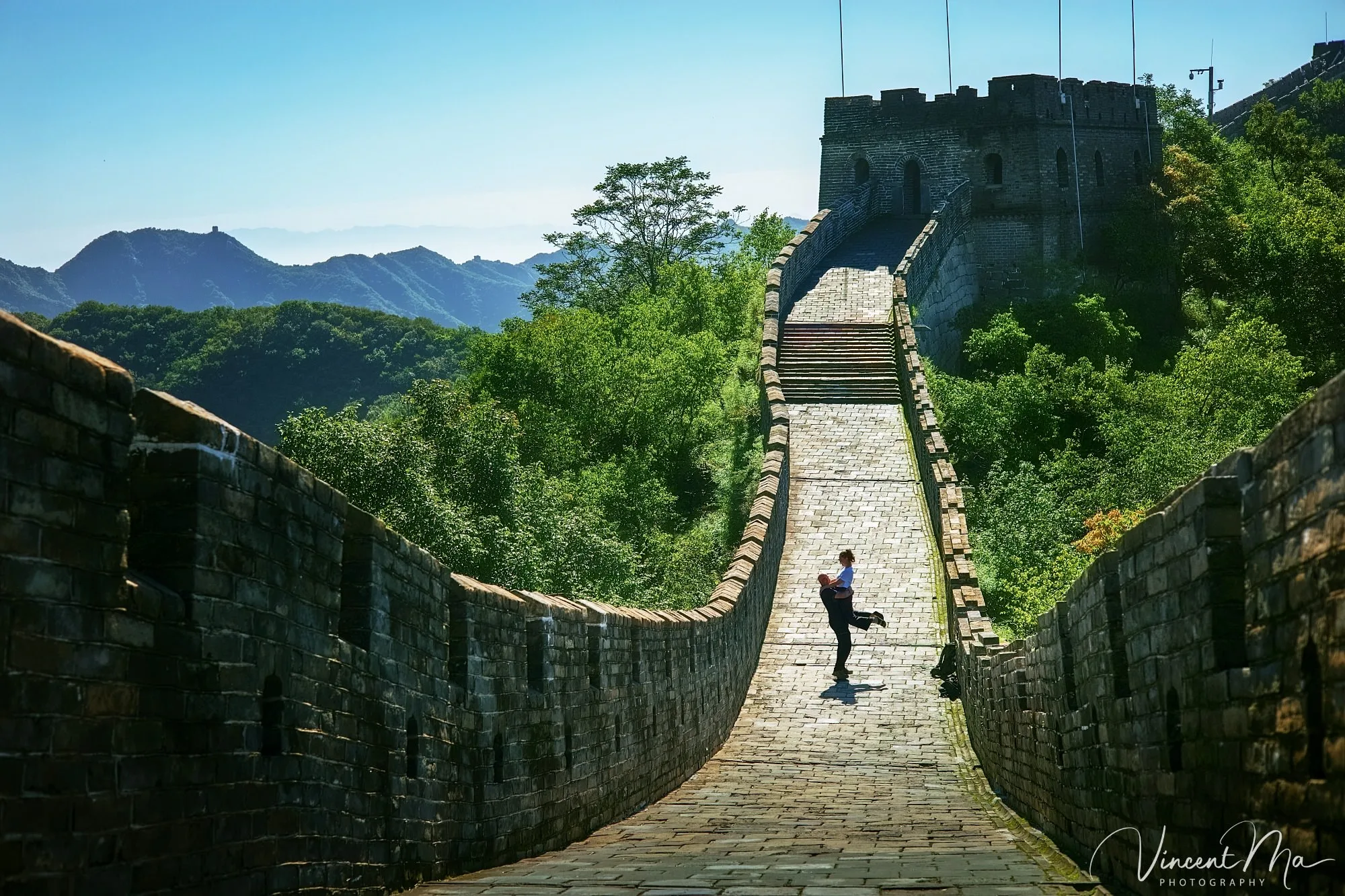 An American couple posing for romantic pictures against the backdrop of Mutianyu Great Wall in Beijing, China. The Great Wall winds through the mountains, and the couple shows their love in the photos.Beijing photoshoot