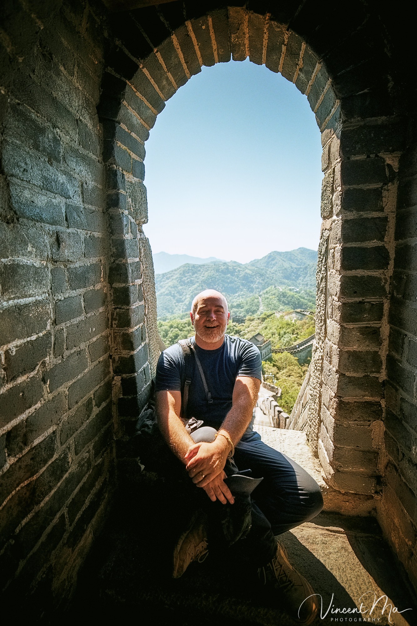 An American couple posing for romantic pictures against the backdrop of Mutianyu Great Wall in Beijing, China. The Great Wall winds through the mountains, and the couple shows their love in the photos