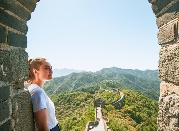 An American couple posing for romantic pictures against the backdrop of Mutianyu Great Wall in Beijing, China. The Great Wall winds through the mountains, and the couple shows their love in the photos