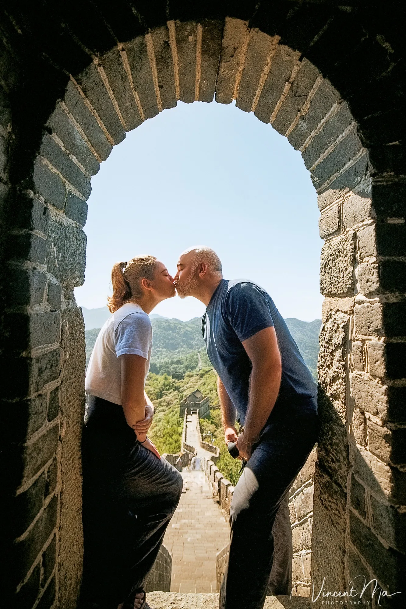 An American couple posing for romantic pictures against the backdrop of Mutianyu Great Wall in Beijing, China. The Great Wall winds through the mountains, and the couple shows their love in the photos.Beijing photoshoot-Beijing photographer