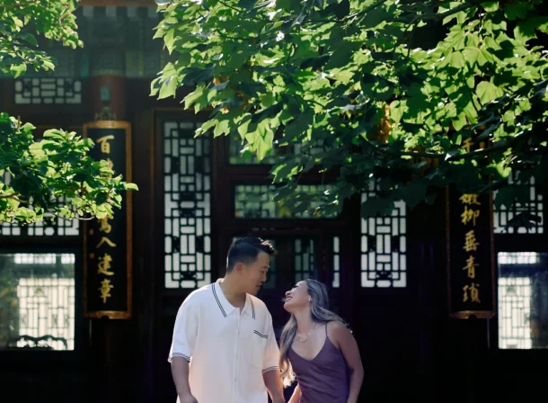 Couple enjoying a romantic moment at the Garden of Harmonious Interests in Beijing's Summer Palace, surrounded by traditional Chinese garden scenery with lakes and pavilions. Engagement shooting in summer palace.