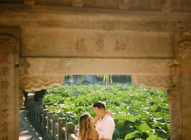 Couple enjoying a romantic moment at the Garden of Harmonious Interests in Beijing's Summer Palace, surrounded by traditional Chinese garden scenery with lakes and pavilions. Engagement shooting in summer palace.