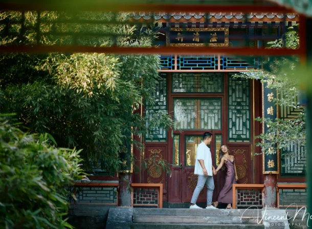 Couple enjoying a romantic moment at the Garden of Harmonious Interests in Beijing's Summer Palace, surrounded by traditional Chinese garden scenery with lakes and pavilions. Engagement shooting in summer palace.