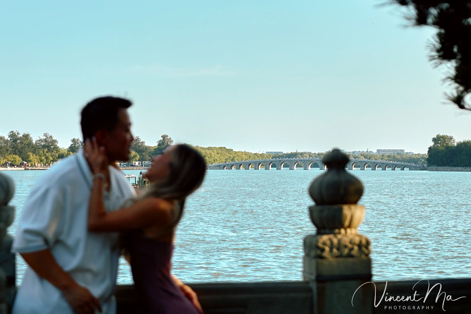 Couple enjoying a romantic moment at The Long Corridor in Beijing's Summer Palace, surrounded by traditional Chinese garden scenery with lakes and pavilions. Engagement shooting in summer palace. 