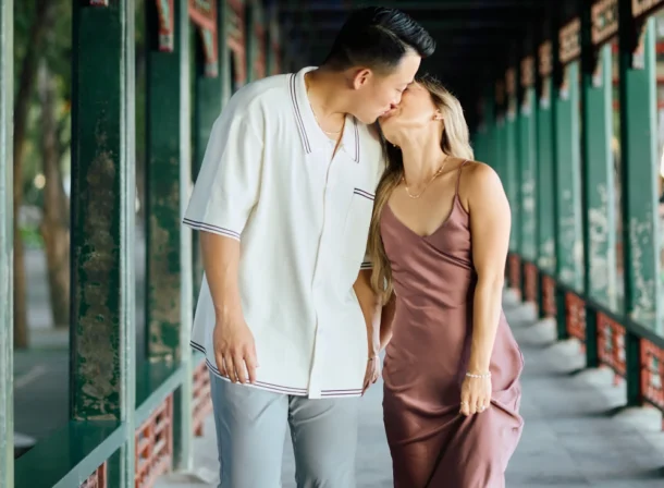 Couple enjoying a romantic moment at The Long Corridor in Beijing's Summer Palace, surrounded by traditional Chinese garden scenery with lakes and pavilions. Engagement shooting in summer palace.