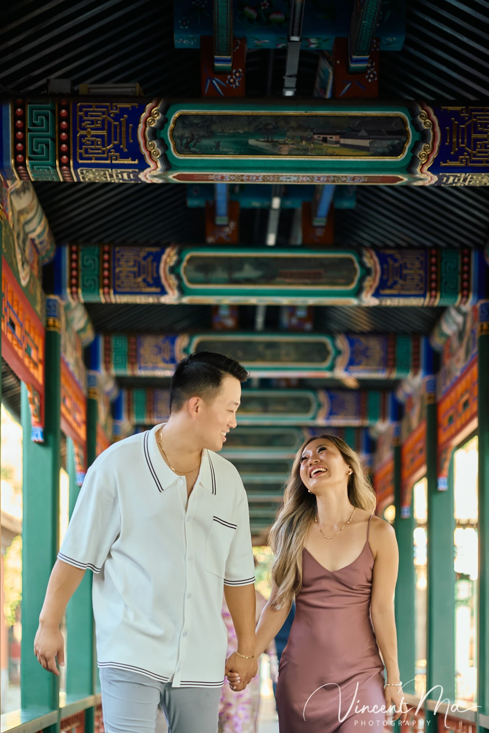 Couple enjoying a romantic moment at The Long Corridor in Beijing's Summer Palace, surrounded by traditional Chinese garden scenery with lakes and pavilions. Engagement shooting in summer palace. 