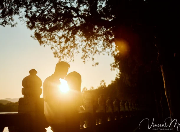 A couple shares an intimate moment with the magnificent architecture of the Summer Palace in sunset in the background.