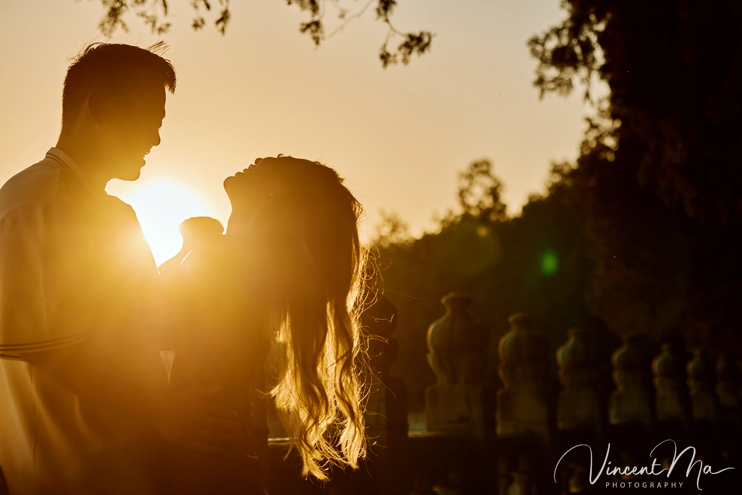 A couple shares an intimate moment with the magnificent architecture of the Summer Palace in sunset in the background.