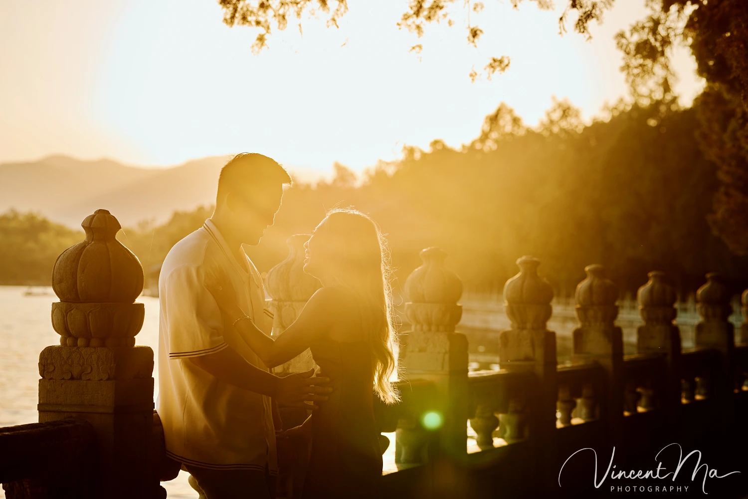 A couple shares an intimate moment with the magnificent architecture of the Summer Palace in sunset in the background.