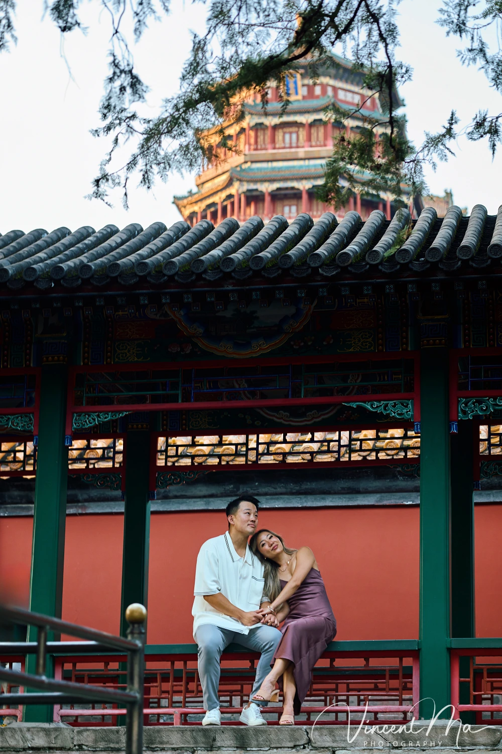 A couple shares an intimate moment with the magnificent architecture of the Summer Palace in sunset in the background.