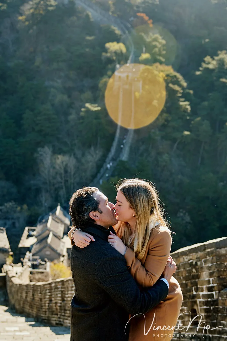 Man proposing to woman on Mutianyu Great Wall during autumn with mountains in background