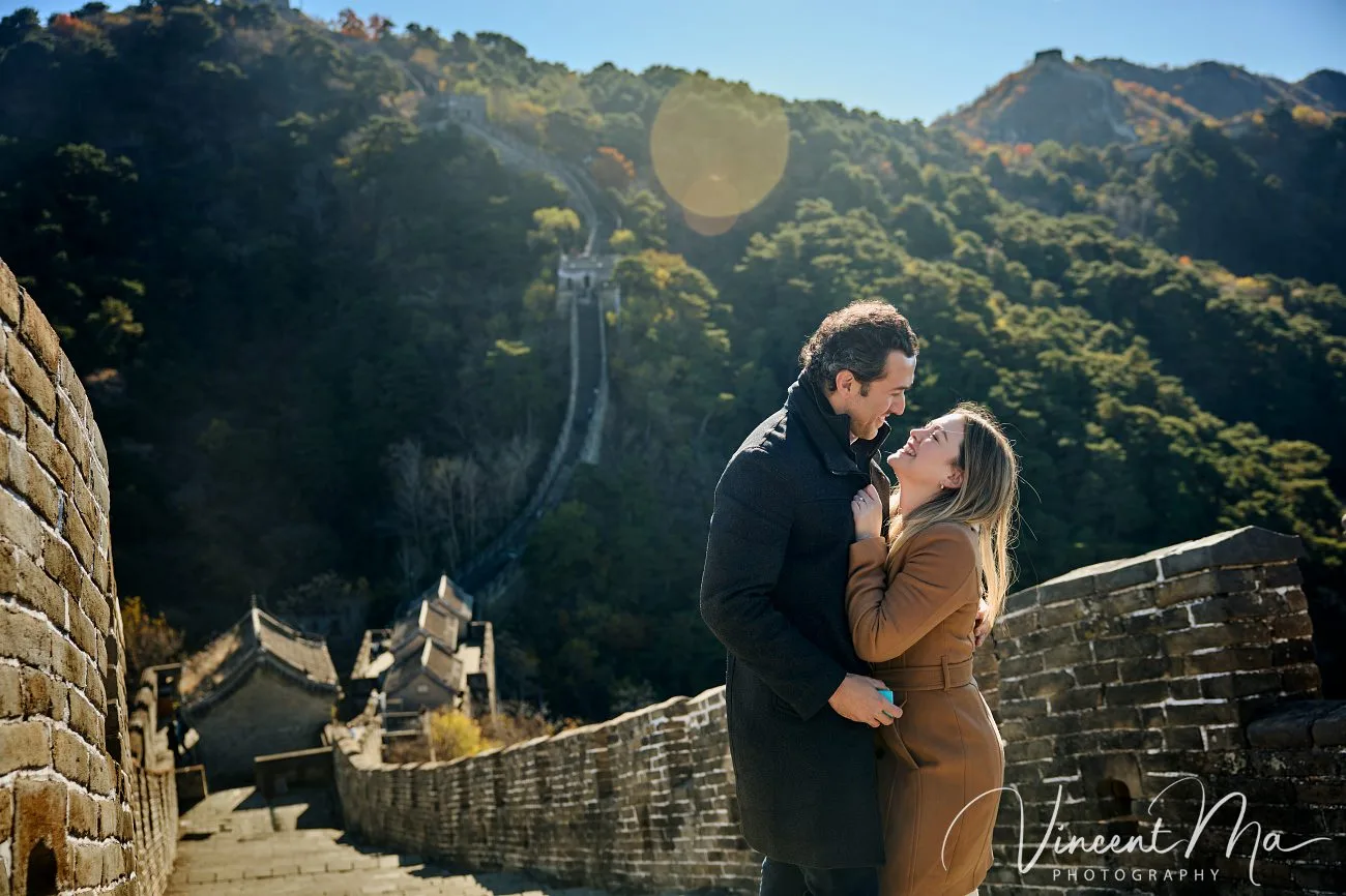 Man proposing to woman on Mutianyu Great Wall during autumn with mountains in background.Beijing photoshoot
