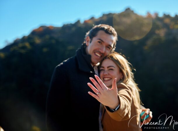 Man proposing to woman on Mutianyu Great Wall during autumn with mountains in background