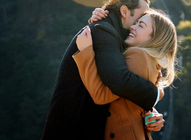 Man proposing to woman on Mutianyu Great Wall during autumn with mountains in background