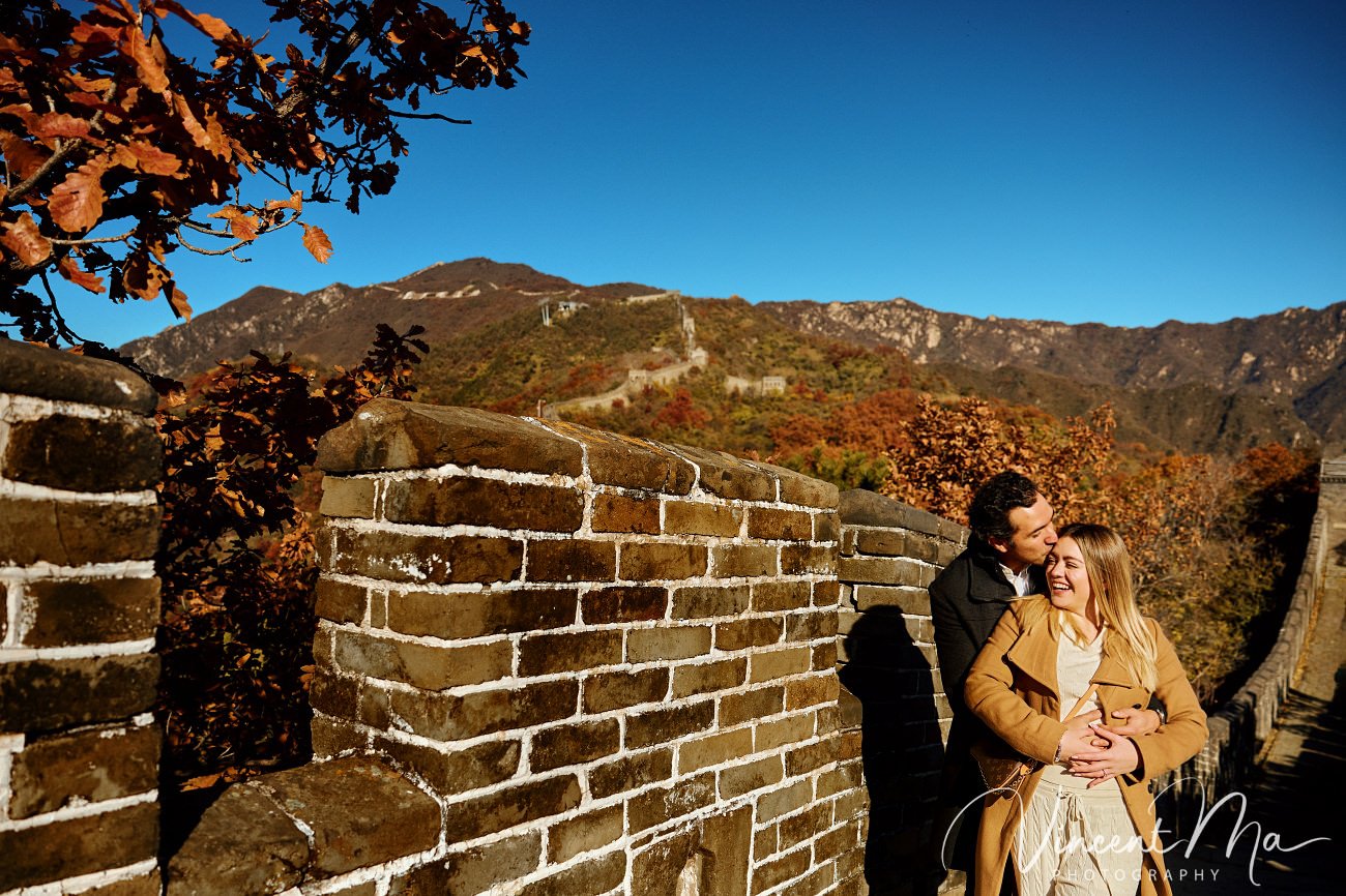 Surprise marriage proposal engagement shooting on Mutianyu Great Wall with ancient bricks and autumn leaves in background