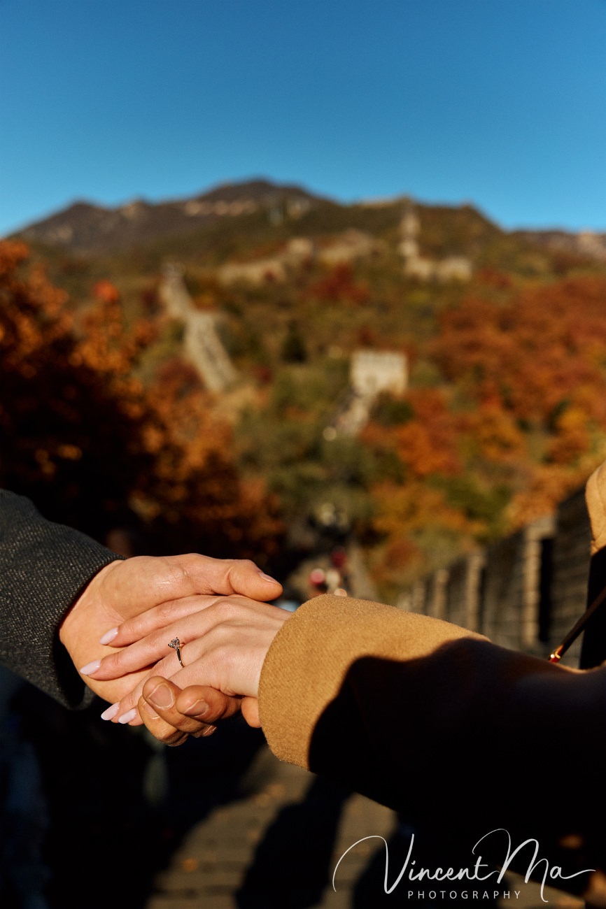 Surprise marriage proposal engagement shooting on Mutianyu Great Wall with ancient bricks and autumn leaves in background
