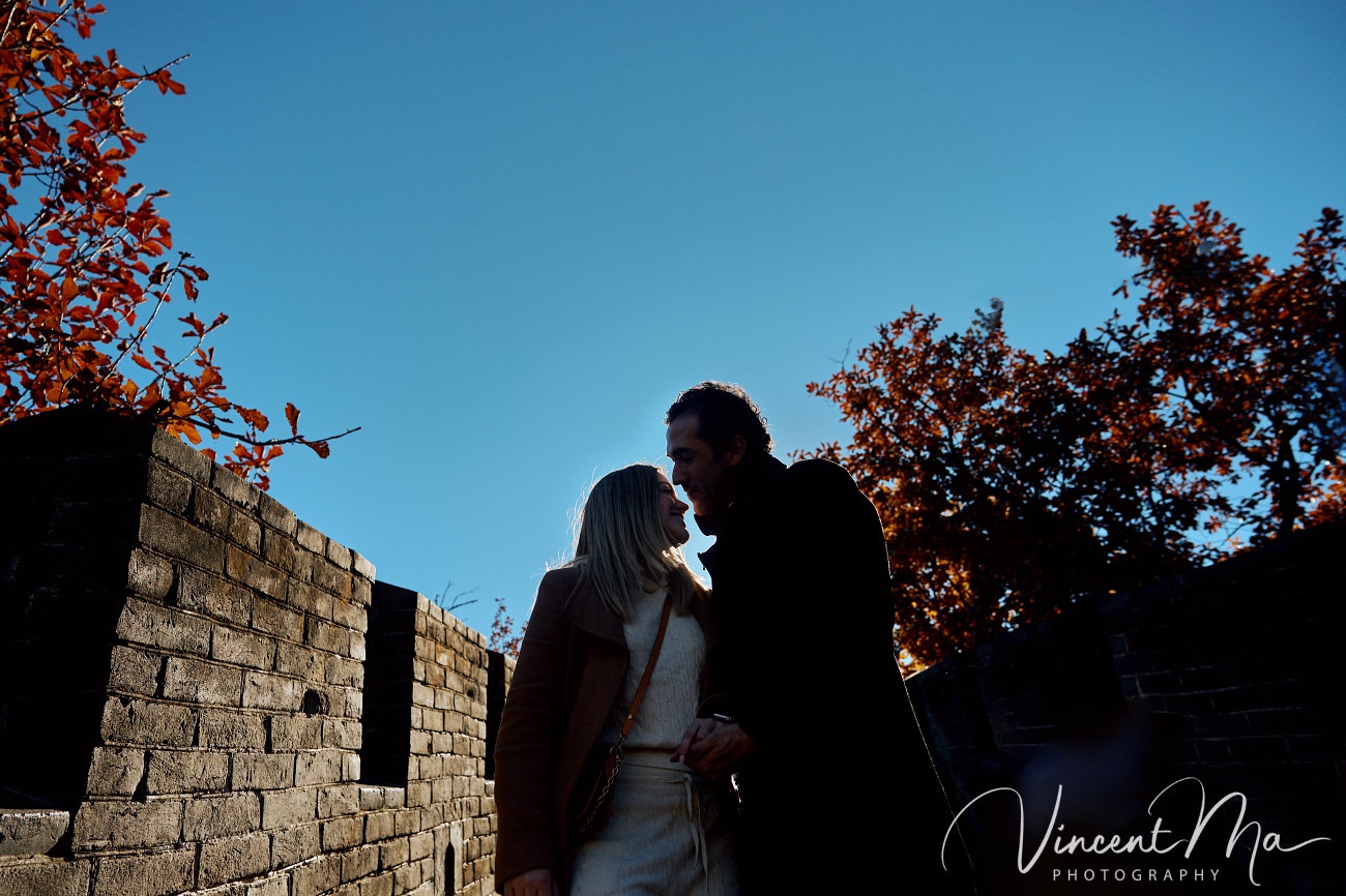 Surprise marriage proposal engagement shooting on Mutianyu Great Wall with ancient bricks and autumn leaves in background
