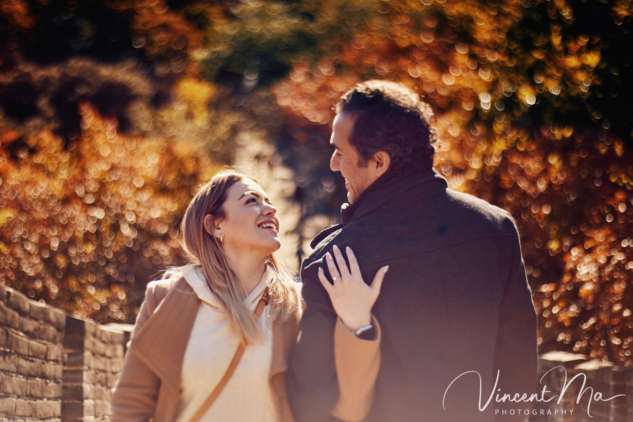 Surprise marriage proposal engagement shooting on Mutianyu Great Wall with ancient bricks and autumn leaves in background