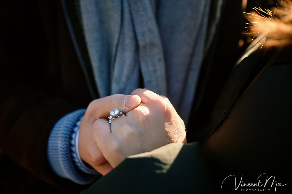 Beijing proposal.Close-up macro shot of a diamond engagement ring resting in the palm of a hand, illuminated by warm sunlight. Highlighting the sparkle and detail of the ring.