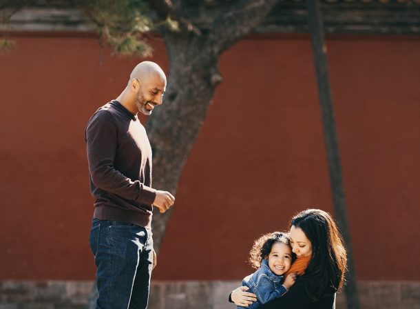US family of three with toddler laughing in front of the Hall of Supreme Harmony at Forbidden City, blue sky and no tourists.Family photography by Vincent Ma