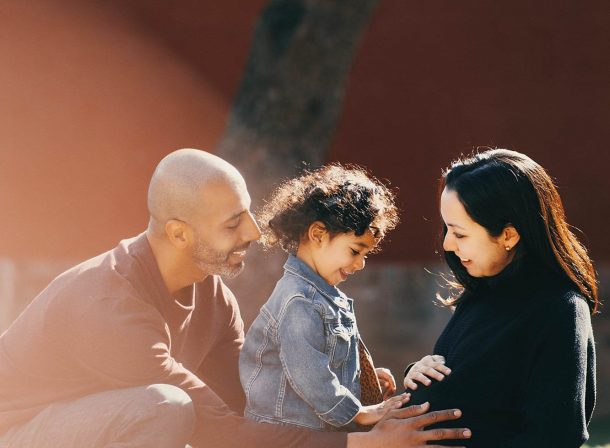 US family of three with toddler laughing in front of the Hall of Supreme Harmony at Forbidden City, blue sky and no tourists.Family photography by Vincent Ma