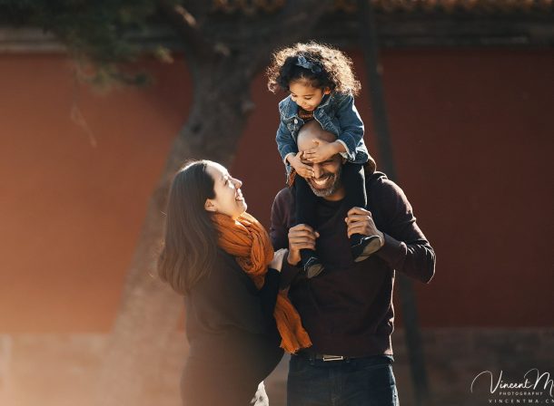 US family of three with toddler laughing in front of the Hall of Supreme Harmony at Forbidden City, blue sky and no tourists.Family photography by Vincent Ma