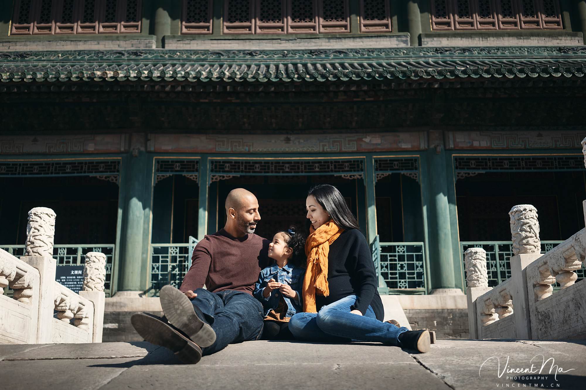 US family of three with toddler laughing in front of the Hall of Supreme Harmony at Forbidden City, blue sky and no tourists.Family photography by Vincent Ma
