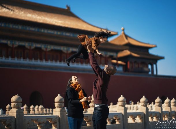 US family of three with toddler laughing in front of the Hall of Supreme Harmony at Forbidden City, blue sky and no tourists.Family photography by Vincent Ma