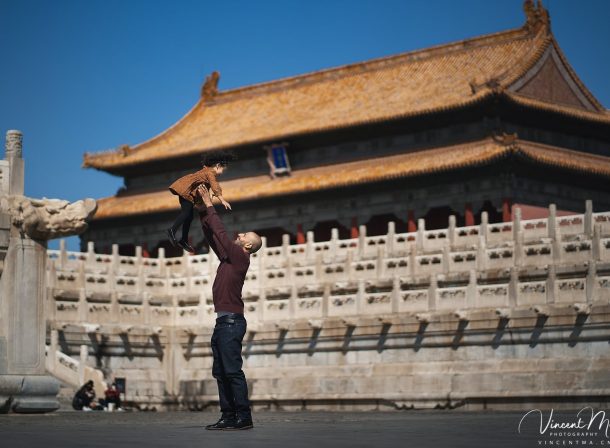 US family of three with toddler laughing in front of the Hall of Supreme Harmony at Forbidden City, blue sky and no tourists.Family photography by Vincent Ma