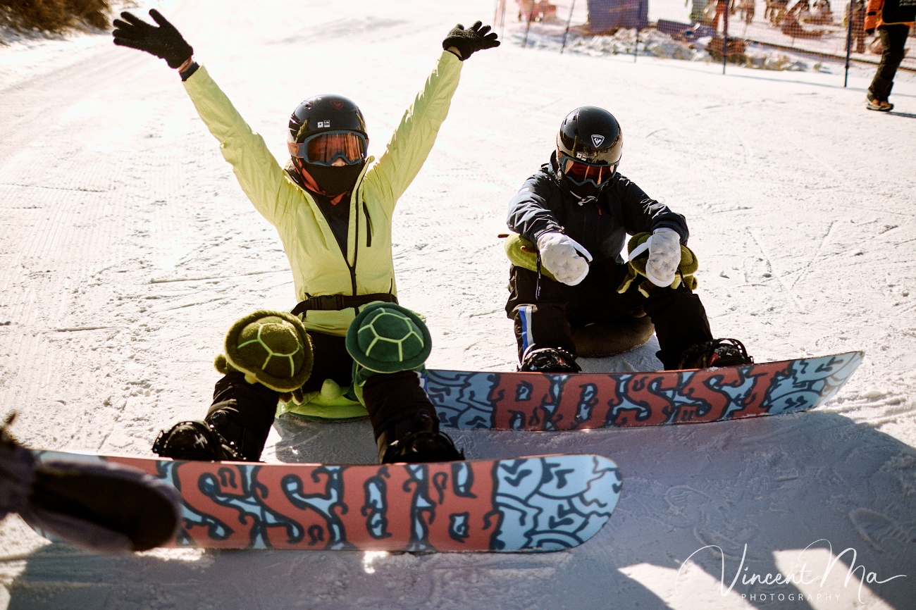 Same-sex couple Claire and April holding hands on a snowy slope in Chongli at a ski resort to celebrate their online wedding.