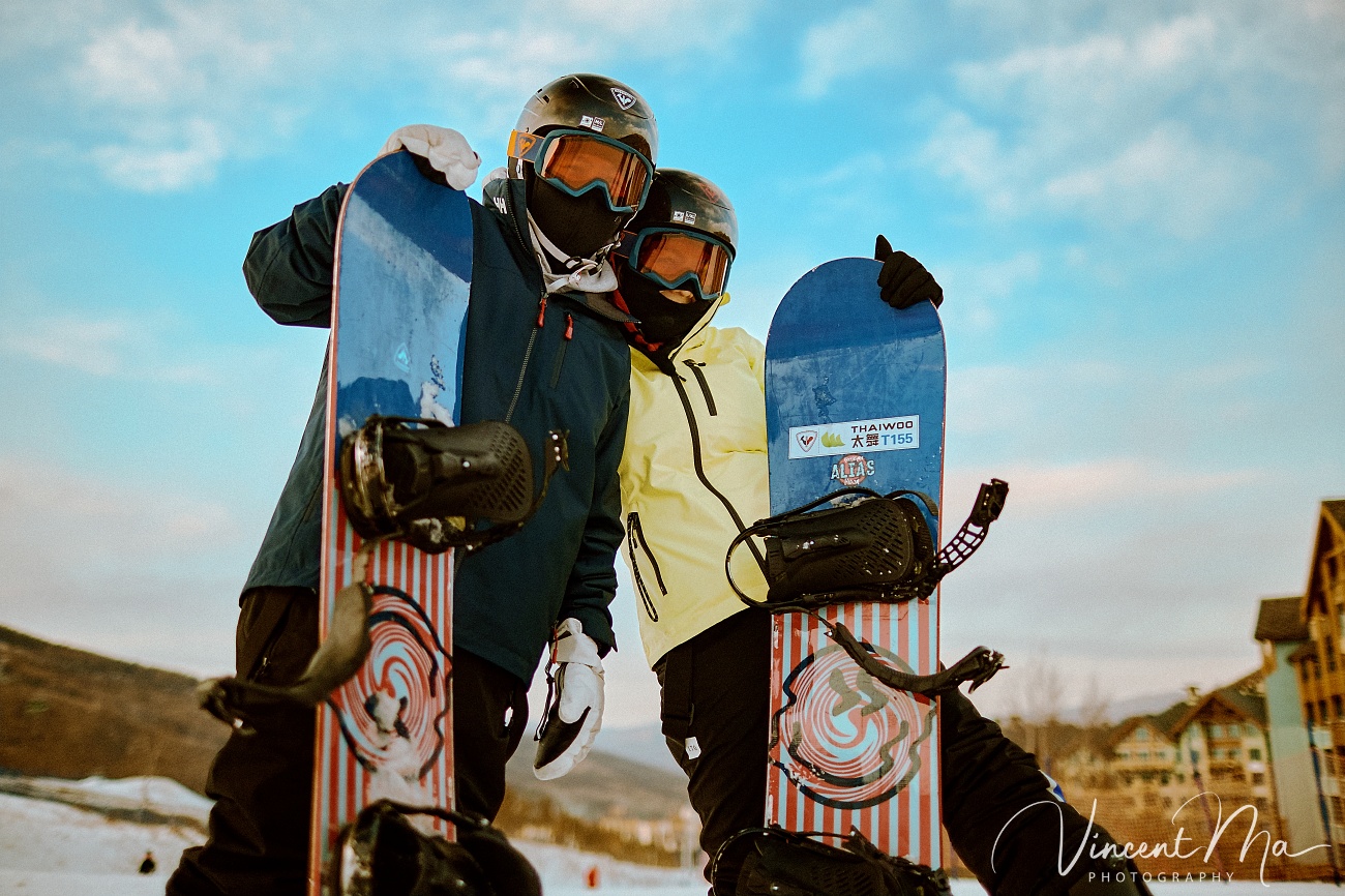 Same-sex couple Claire and April holding hands on a snowy slope in Chongli at a ski resort to celebrate their online wedding.