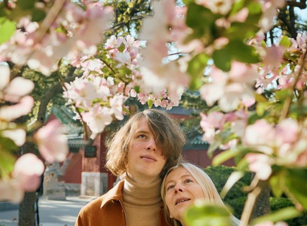 Cinematic portrait of a mother admiring white magnolias in Ritan Park Beijing by Vincent Ma.