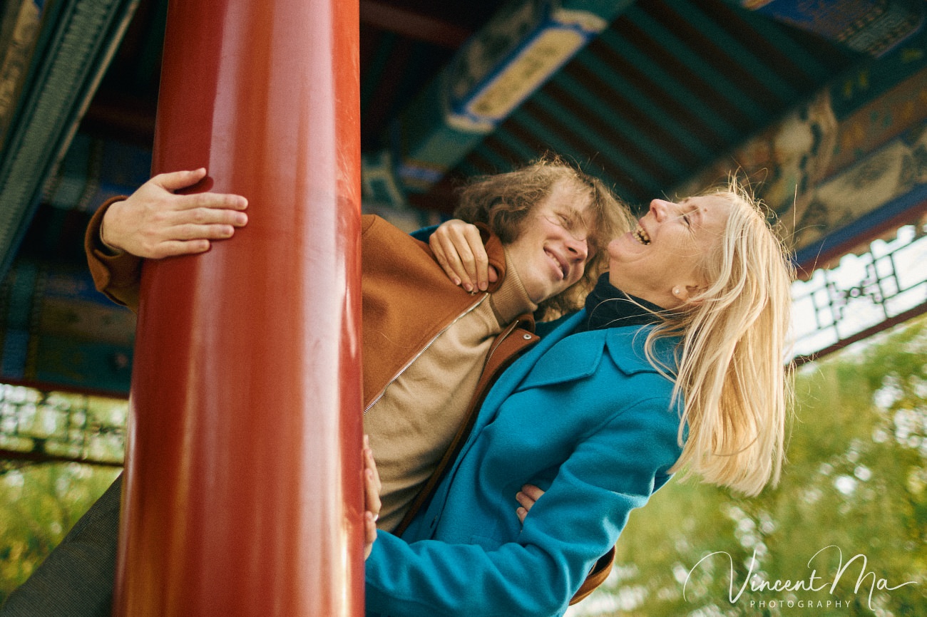 Family travel photography in Beijing featuring traditional red walls and golden hour sunlight.
