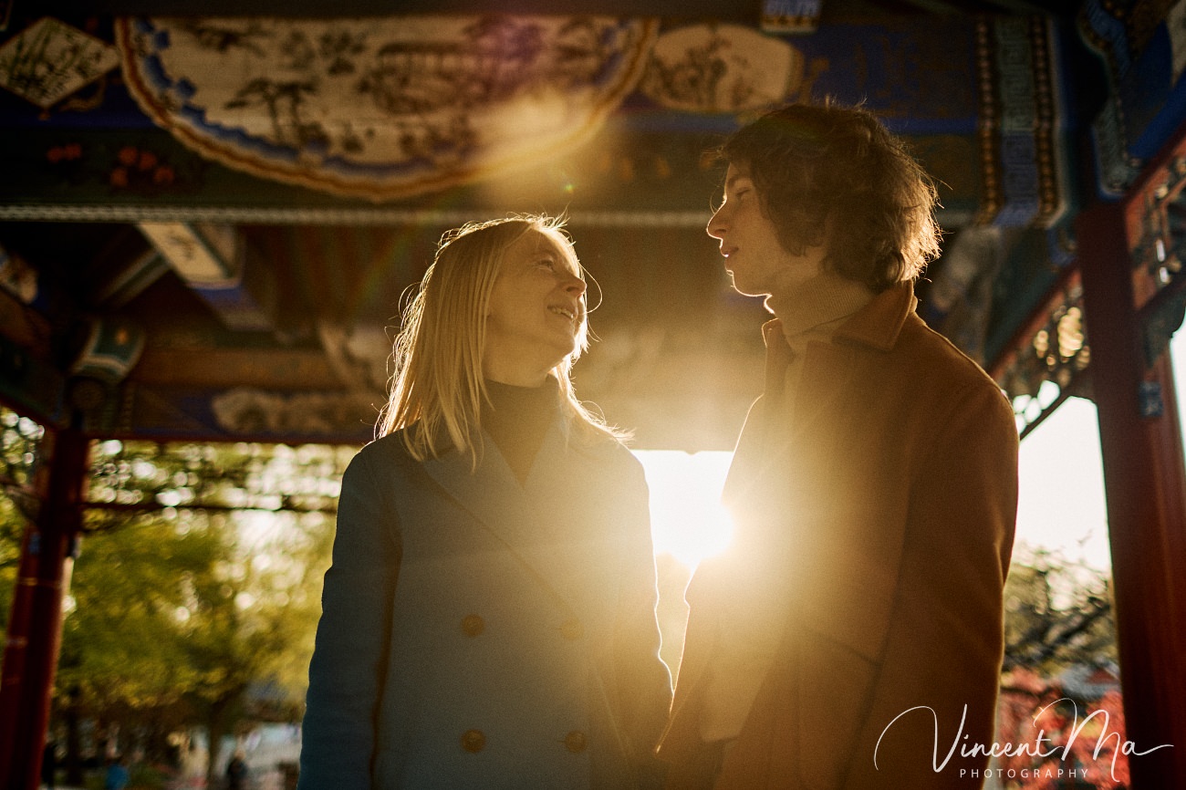 Family travel photography in Beijing featuring traditional red walls and golden hour sunlight.