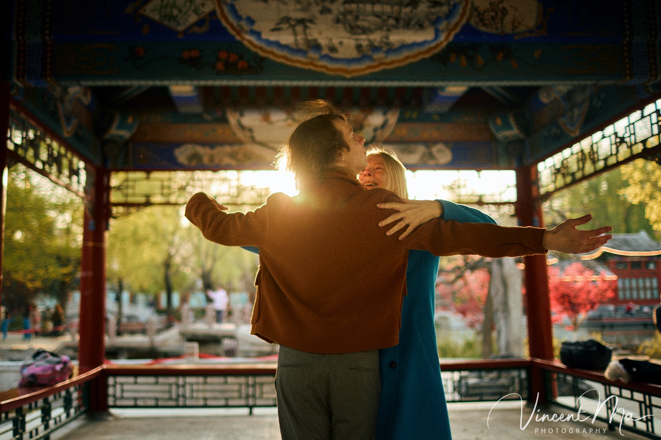 Family travel photography in Beijing featuring traditional red walls and golden hour sunlight.