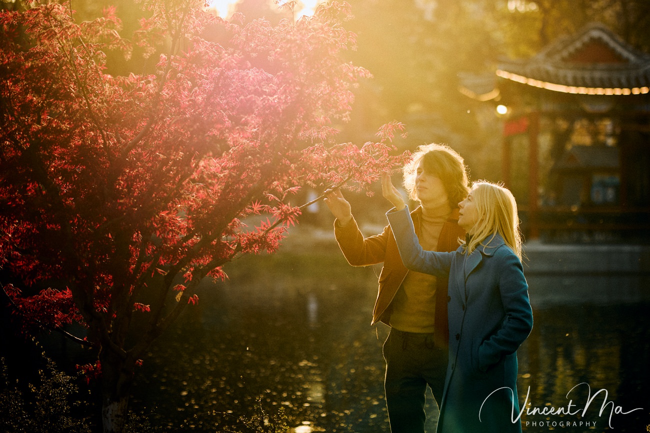 Family travel photography in Beijing featuring traditional red walls and golden hour sunlight.
