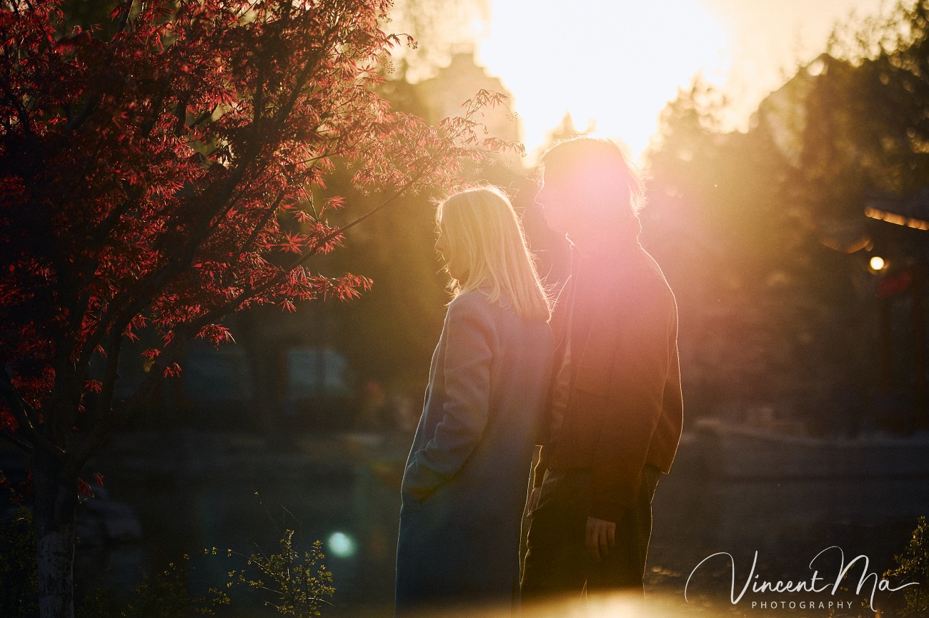 Family travel photography in Beijing featuring traditional red walls and golden hour sunlight.