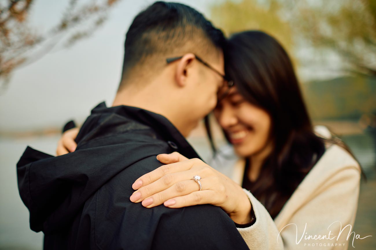 Breathtaking moment of a secret proposal at the Summer Palace, Beijing. A man on one knee amidst spring flowers and ancient imperial architecture. Captured by Beijing photographer Vincent Ma.